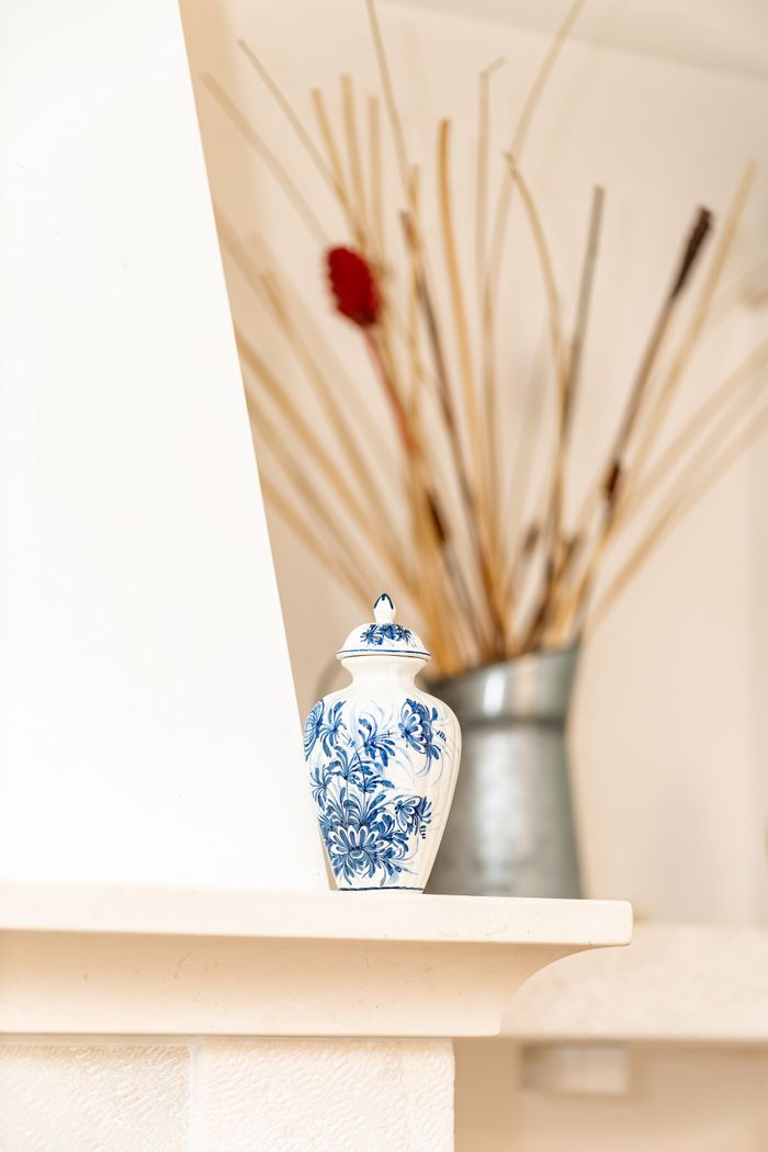 A close-up of a porcelain vase with dried flowers, adding elegance to home decor.